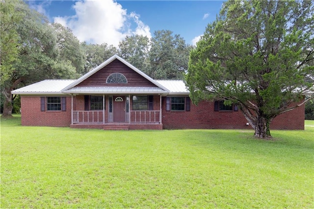 single story home with covered porch, a front yard, metal roof, and brick siding