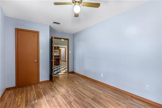 unfurnished bedroom with a ceiling fan, light wood-type flooring, visible vents, and baseboards