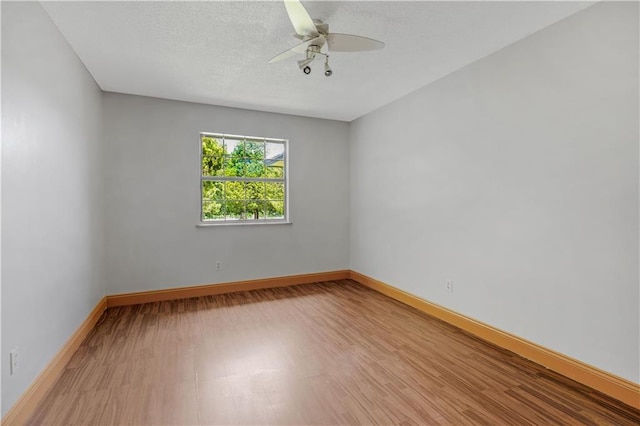 unfurnished room with a textured ceiling, ceiling fan, and hardwood / wood-style floors