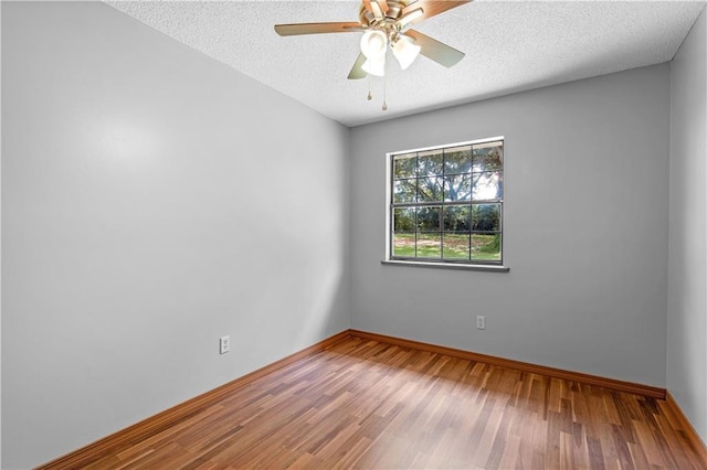 unfurnished room featuring ceiling fan, a textured ceiling, baseboards, and wood finished floors