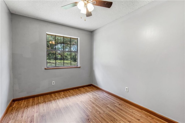 unfurnished room with a ceiling fan, a textured ceiling, baseboards, and wood finished floors