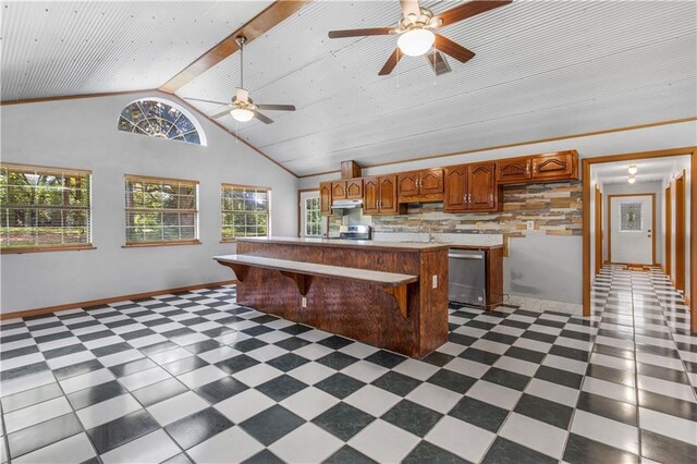 kitchen with ceiling fan, dark tile patterned flooring, and a healthy amount of sunlight