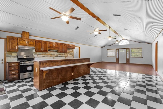 kitchen featuring ceiling fan, tasteful backsplash, stainless steel range oven, light tile patterned flooring, and lofted ceiling with beams