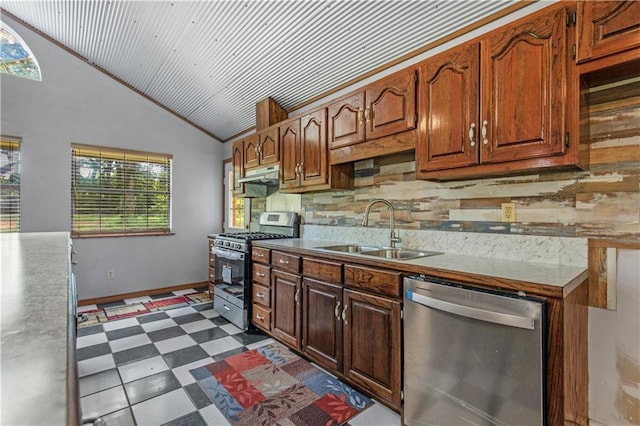 kitchen with dark floors, appliances with stainless steel finishes, vaulted ceiling, under cabinet range hood, and a sink