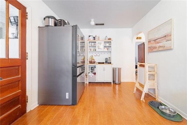 kitchen with stainless steel fridge and light hardwood / wood-style floors