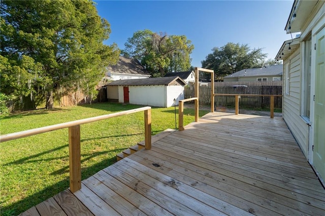 wooden terrace featuring a yard and a storage unit