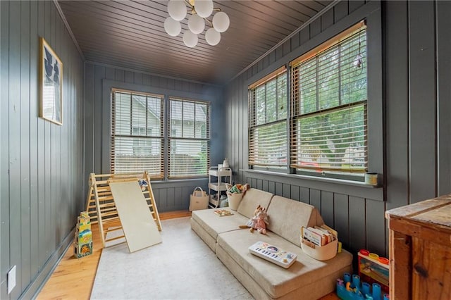 living area with wood walls, light hardwood / wood-style flooring, and wooden ceiling