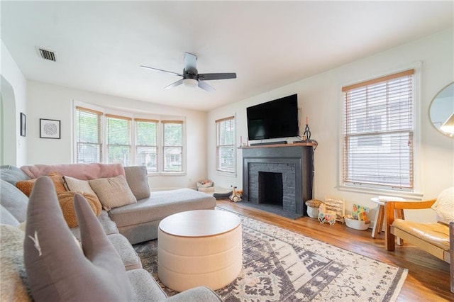 living room with hardwood / wood-style flooring, a brick fireplace, plenty of natural light, and ceiling fan