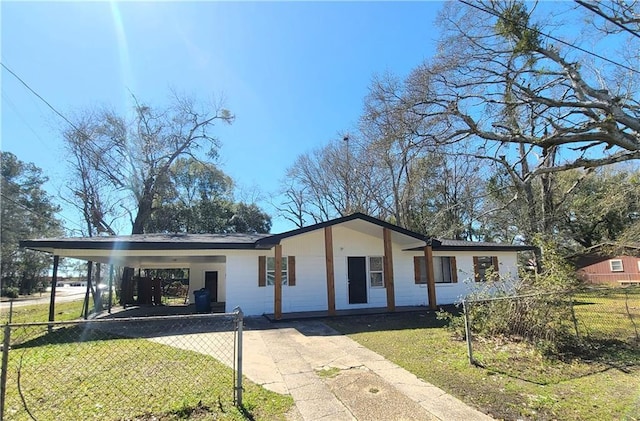 view of front facade with a carport, driveway, a front lawn, and fence