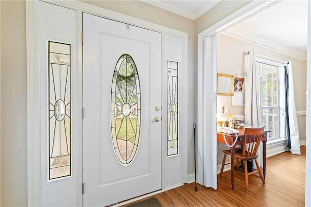 entrance foyer with wood-type flooring, ornamental molding, and a wealth of natural light