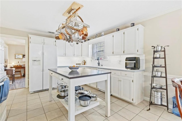 kitchen featuring white cabinetry, hanging light fixtures, crown molding, white appliances, and light tile patterned flooring