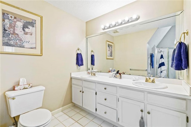 bathroom featuring tile patterned flooring, vanity, a textured ceiling, and toilet