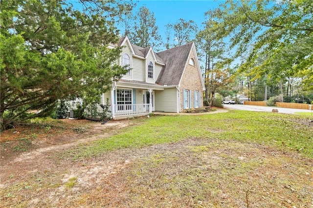 view of side of home with a porch and a lawn