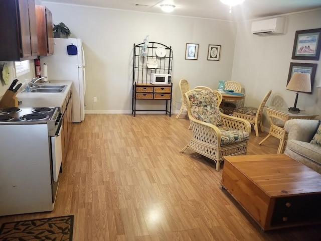 interior space with white appliances, sink, ornamental molding, light wood-type flooring, and a wall mounted AC