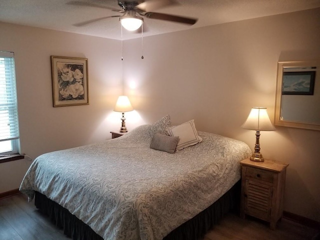 bedroom with ceiling fan, wood-type flooring, and multiple windows