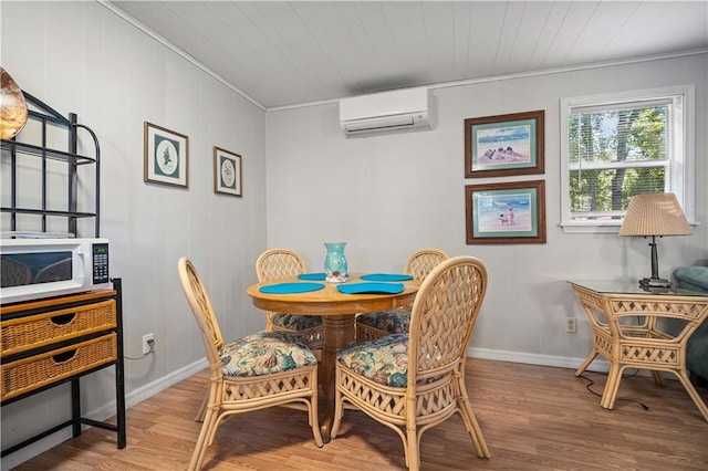 dining room featuring wood-type flooring, a wall mounted air conditioner, and ornamental molding