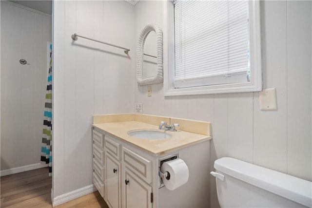 bathroom with wood-type flooring, vanity, toilet, and wood walls