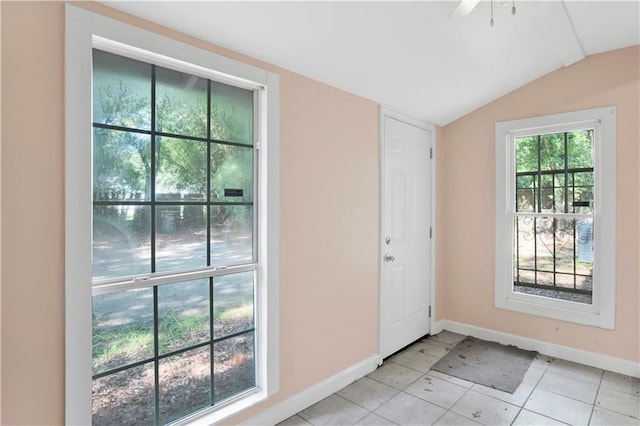 entryway featuring ceiling fan, light tile patterned flooring, and lofted ceiling