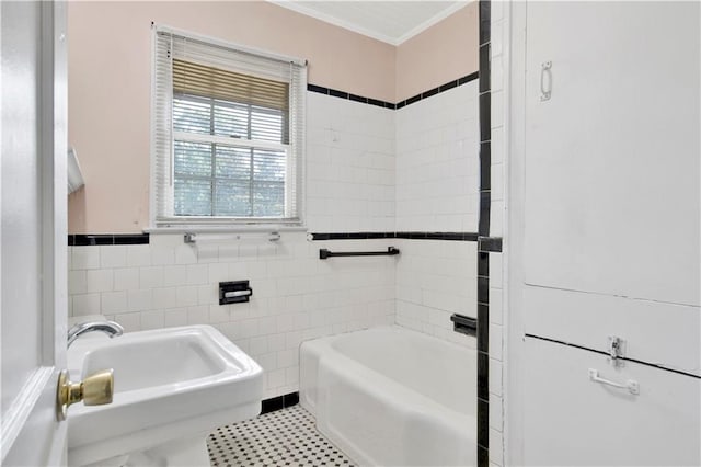 bathroom with a tub to relax in, crown molding, sink, tile walls, and tile patterned flooring