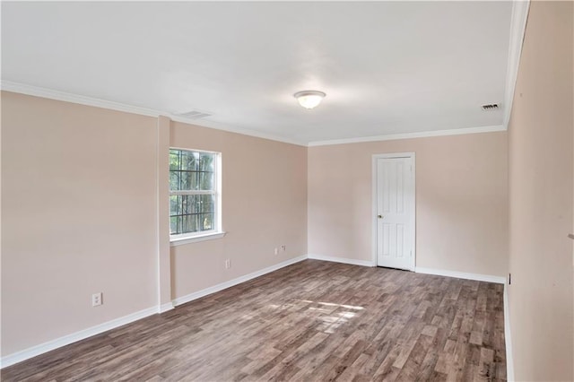 empty room with hardwood / wood-style floors and crown molding