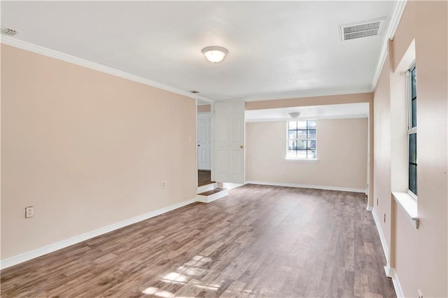 spare room featuring hardwood / wood-style flooring and ornamental molding