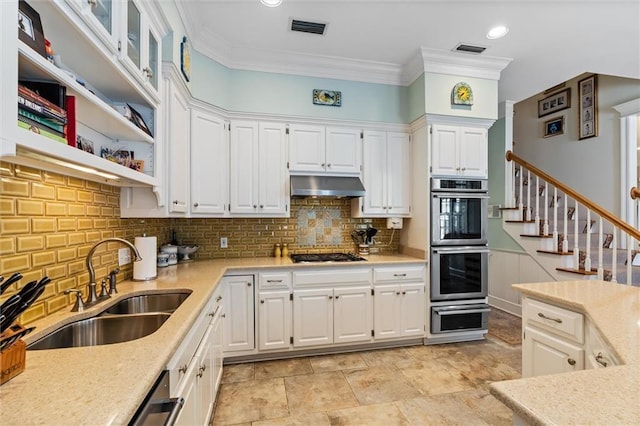 kitchen with gas cooktop, ornamental molding, double oven, sink, and white cabinets