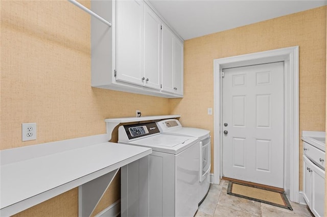 clothes washing area with cabinets and washing machine and dryer