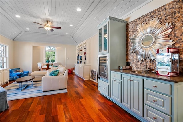 living room featuring dark hardwood / wood-style flooring, wood ceiling, vaulted ceiling, ceiling fan, and sink