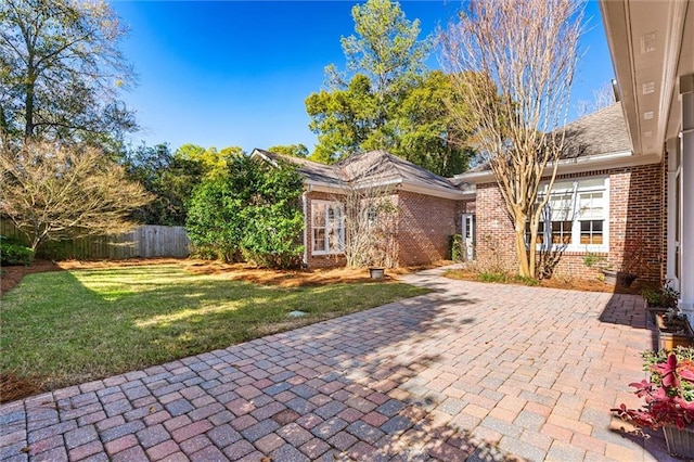 ranch-style home featuring a front lawn and a patio area