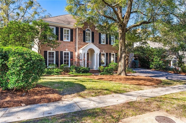 colonial inspired home with a front lawn