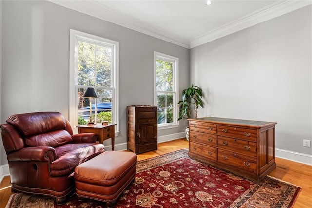 living area with crown molding and light hardwood / wood-style flooring