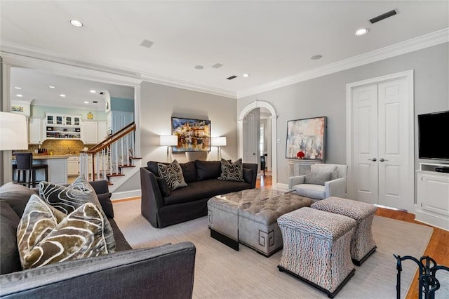 living room with light wood-type flooring and crown molding