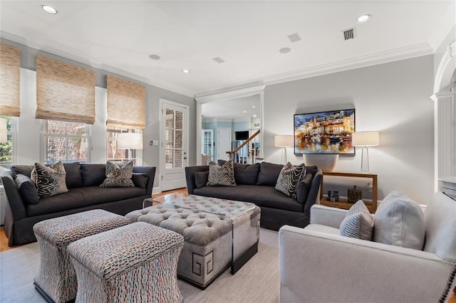 living room with crown molding and light hardwood / wood-style flooring