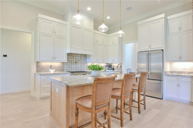 8529 Crepe Myrtle Ct, Mobile, AL 36619 - kitchen featuring light wood-style floors, a kitchen bar, tasteful backsplash, and stainless steel built in refrigerator