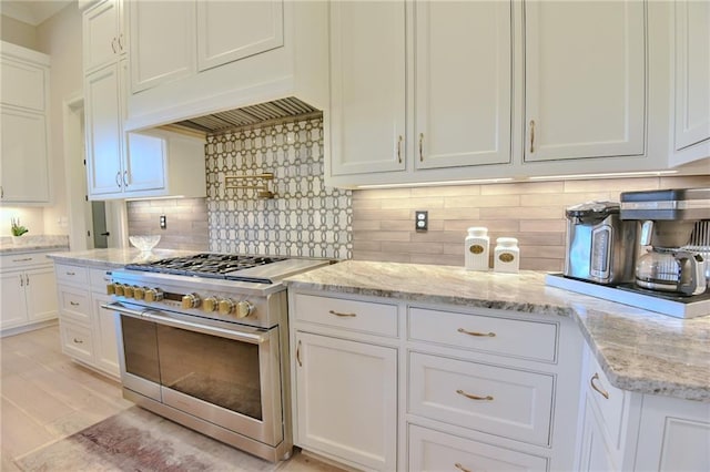 8529 Crepe Myrtle Ct, Mobile, AL 36619 - kitchen with backsplash, range with two ovens, light stone countertops, light wood-type flooring, and white cabinets