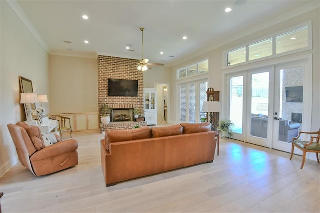 8529 Crepe Myrtle Ct, Mobile, AL 36619 - living room featuring ceiling fan, light wood finished floors, a brick fireplace, french doors, and ornamental molding