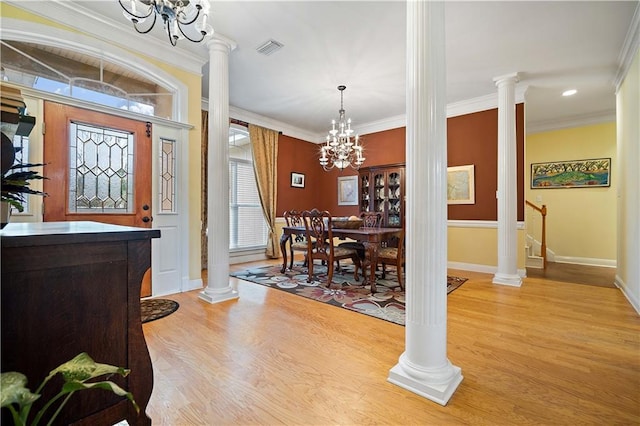 dining space with decorative columns, crown molding, light hardwood / wood-style flooring, and a chandelier