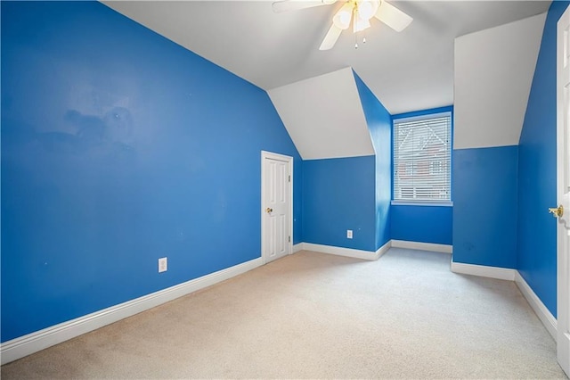 additional living space with ceiling fan, light colored carpet, and vaulted ceiling