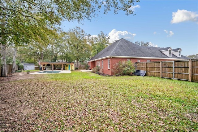 view of yard featuring a fenced in pool and an outbuilding