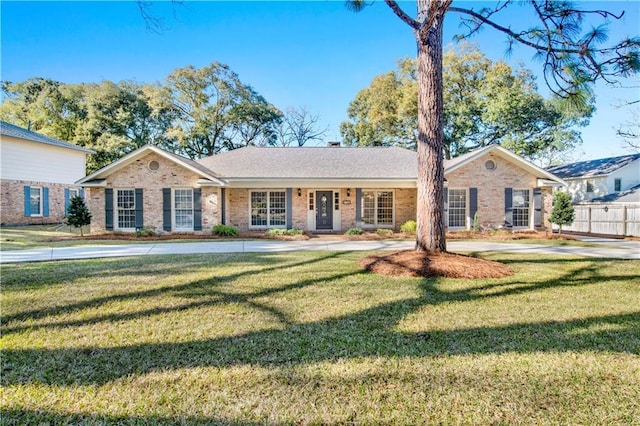 ranch-style house with brick siding, fence, and a front lawn