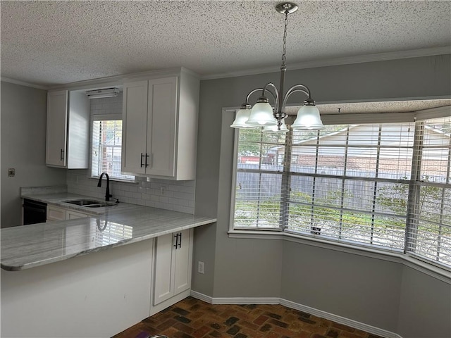 kitchen featuring pendant lighting, backsplash, sink, and white cabinets