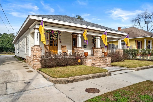 view of front of house featuring covered porch and a front lawn