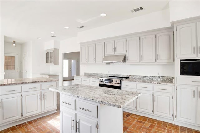 kitchen with white cabinetry, light stone counters, stainless steel electric range oven, and a center island