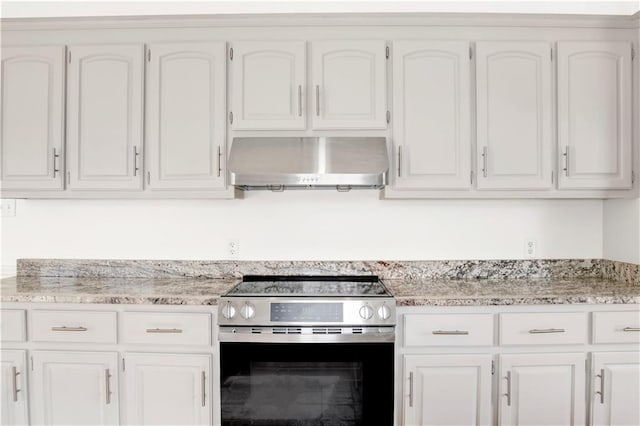 kitchen featuring white cabinets, stainless steel range oven, and wall chimney exhaust hood