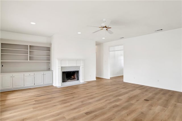 unfurnished living room featuring ceiling fan, light hardwood / wood-style flooring, and a high end fireplace