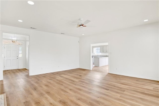 unfurnished living room featuring light wood-type flooring and ceiling fan