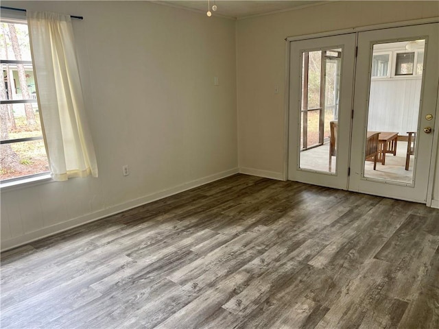 unfurnished room with plenty of natural light, crown molding, french doors, and dark hardwood / wood-style flooring