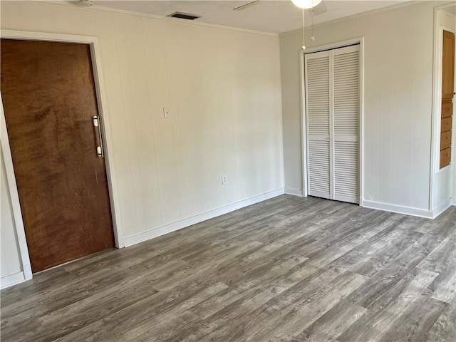 unfurnished bedroom with ceiling fan, crown molding, and dark hardwood / wood-style floors