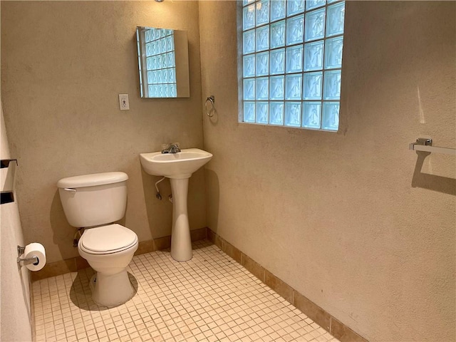 bathroom featuring tile flooring and toilet