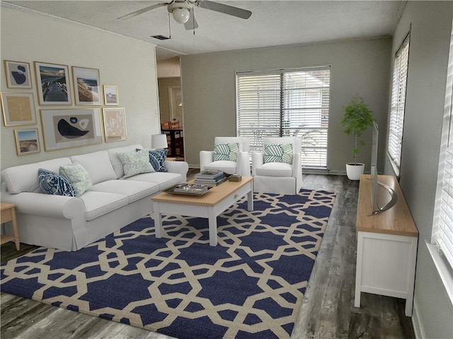 living room with dark hardwood / wood-style flooring, ceiling fan, and plenty of natural light